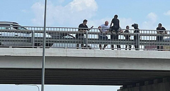 Под Краснодаром перекрыли Тургеневское шоссе из-за мужчины, который сел на перила моста, внизу растянули полотно – ВИДЕО