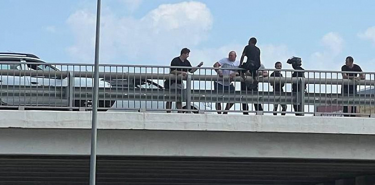 Под Краснодаром перекрыли Тургеневское шоссе из-за мужчины, который сел на перила моста, внизу растянули полотно – ВИДЕО