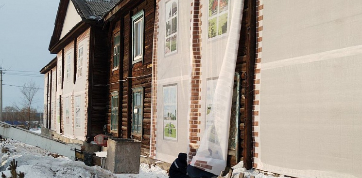 «Чтобы не увидели разваленный барак»: в Кузбассе фасад старого общежития закрыли баннерами к приезду губернатора 